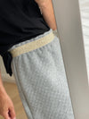 Jupe matelassée gris clair à taille élastiquée. Vous pouvez choisir l'élastique doré apparent ou dissimulé. Coupe légèrement en trapèze et longueur de la jupe sur mesure.