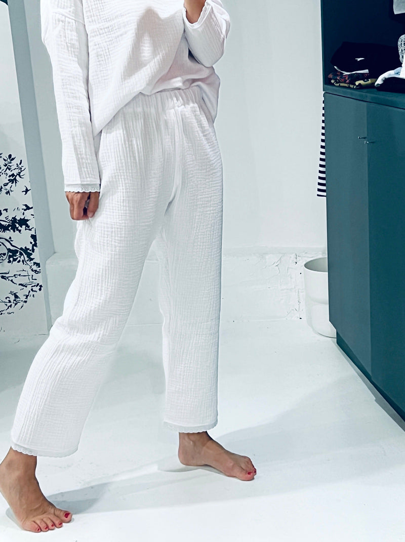 Pyjama long en triple gaze de coton blanche et broderie anglaise blanche en bas des manches et du pantalon. Coupe loose pour le haut et coupe droite pour le pantalon.